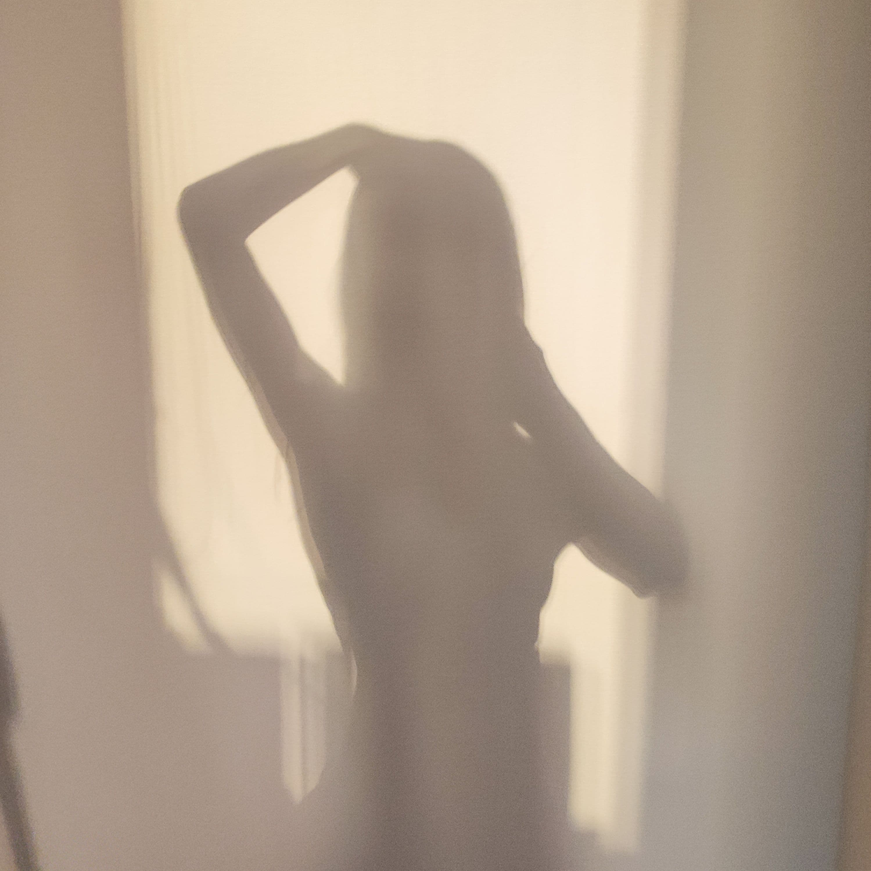 Hands around a cup at a kitchen table in soft morning light